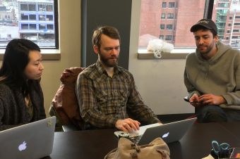 Laughing businesswoman working in office with laptop